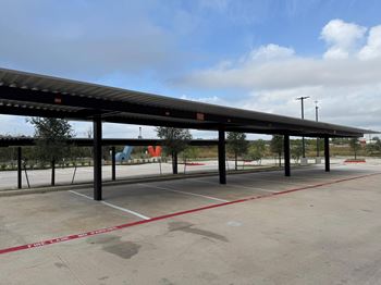 A parking lot with a long covered parking area.